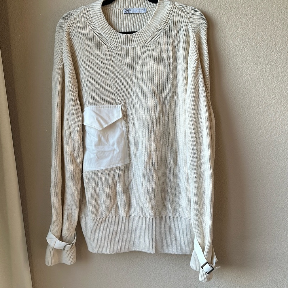 Cream colored sweater with buckle details on sleeves from Zara